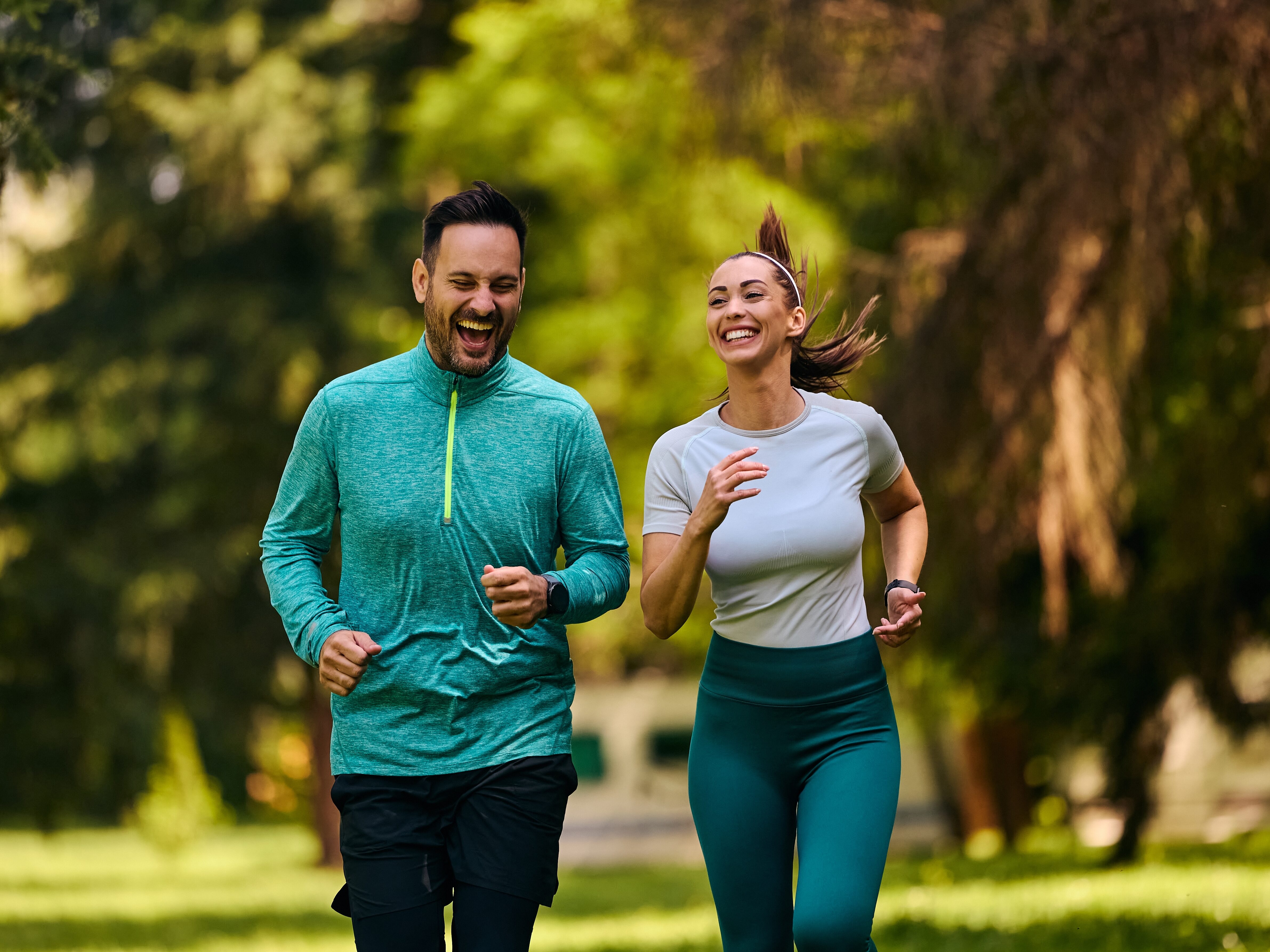 CheerfulCoupleOfAthletesRunningDuringSportsTrainingInThe - HASEBLO ランニングやジョギングを楽しむイメージ